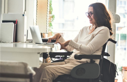 Woman with a disability smiles as she works on her computer