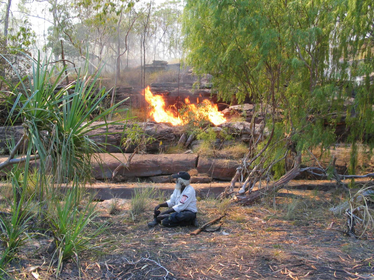 Indigenous ranger in front of fire in the bush