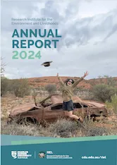 Thumbnail of the front cover of the RIEL Annual Report 2024 showing a researcher jumping in the air in front of a rusted car body in an outback location.