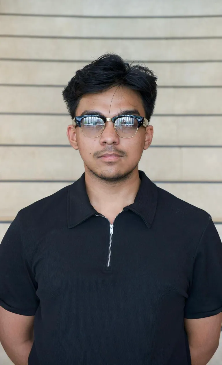 Man wearing glasses and black polo shirt