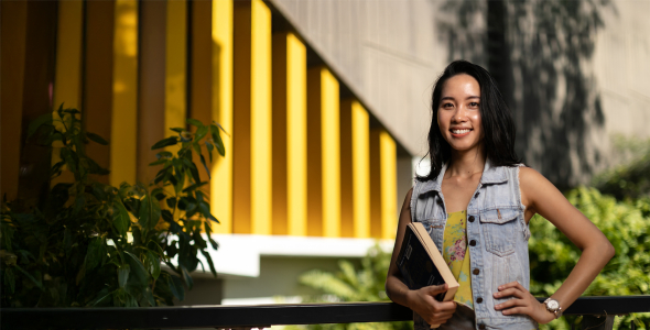 MBA student Ellie holding book on campus