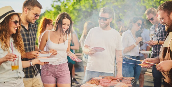  group of middle aged people gathered around a barbeque