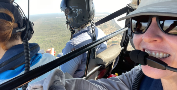 Image of people flying in a helicopter over the land and ocean