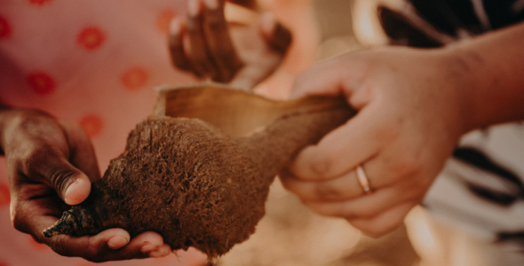 two hands holding shell and communicating 