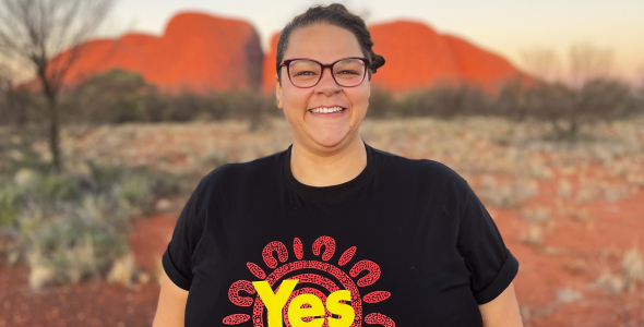 Georgie Corrie stands in front of Uluru