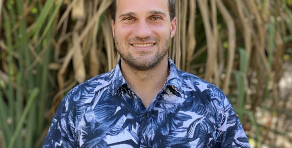 Dr Rafael Bohn Reckziegel, head and chest, wearing blue patterned shirt with long brown and green leaves in the background