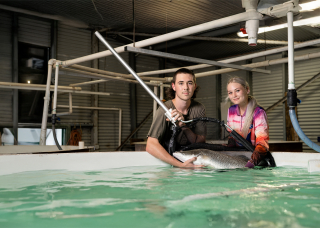 Aquaculture students holding a fish