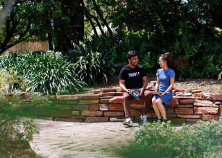 Two students sitting outside on-campus