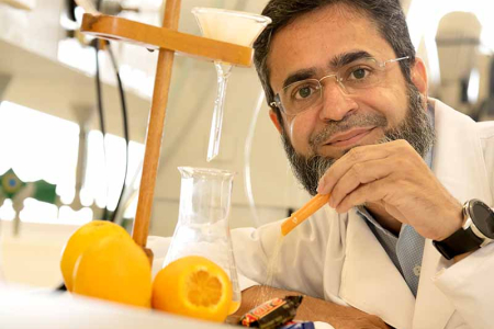 Dr Sufyan Akram pictured in a laboratory with oranges and chocolates.