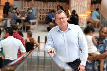 Demographer Andrew Taylor stand on escalator in Casuarina square Darwin