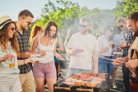  group of middle aged people gathered around a barbeque