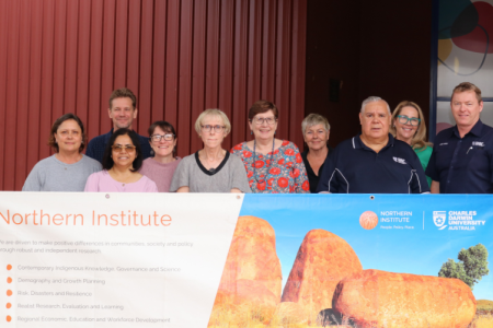 NI staff members infron tof banner in Alice Springs