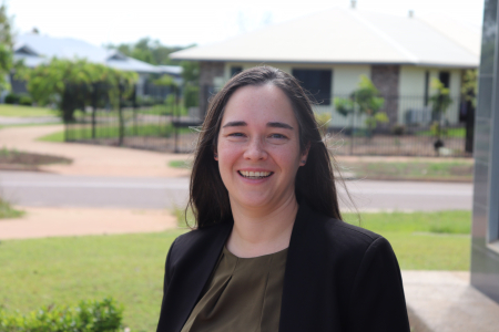 Dr Ingrid Conninx, head and shoulders, wearing black jacket and brown blouse, with green lawn, road and houses out of focus in background