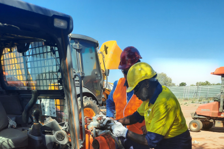 two men work on machinery 