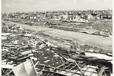 Black and white photo of destroyed houses after Cyclone Tracy hit a suburb of Darwin. 