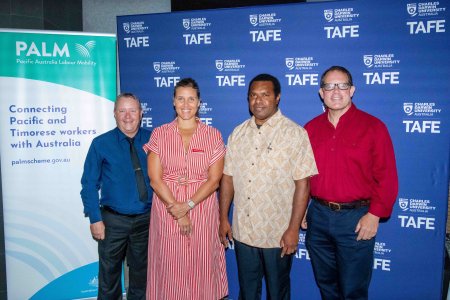 four people stand in front of CDU TAFE logo