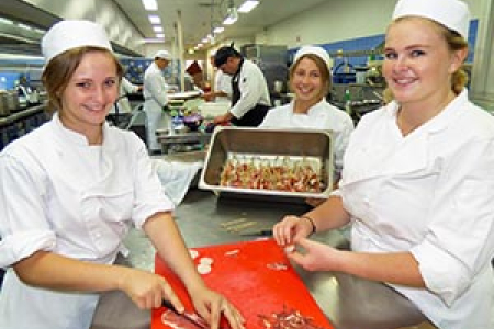 Kitchen operations students Johanna Ezard, Anina Conradie and Suzi Nitschke prepare scallop prosciutto “lollipops” for the degustation menu.