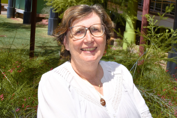 Felicity smiles wearing white shirt and short brown hair with glasses at alice springs campus