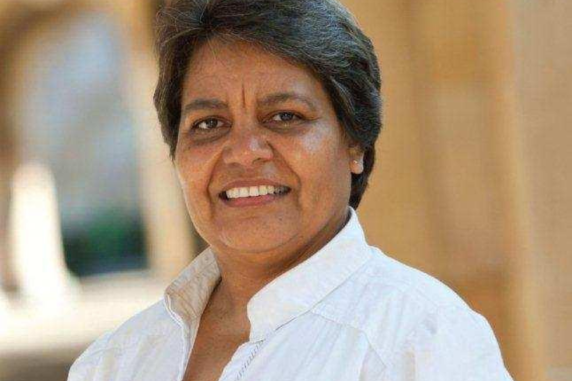 Linda Ford smiling with white shirt against yellow background