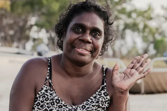 Enid smiling and waving on beach