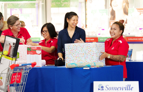 Dr Buaphrao Raphiphatthana helping to wrap Christmas presents with Somerville volunteers at a local shopping centre.uare.