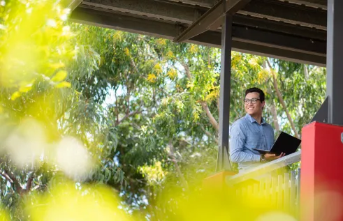 CDU student with a laptop looking confident