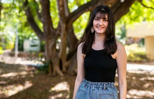 Student standing on campus smiling