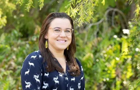 Dr Rebecca Rogers head and shoulders with green leafy vegetation in background