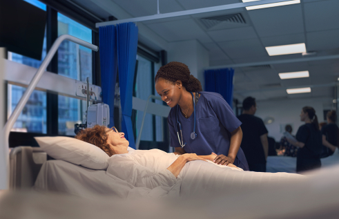 a nursing student in Sydney checking over a patient in bed  