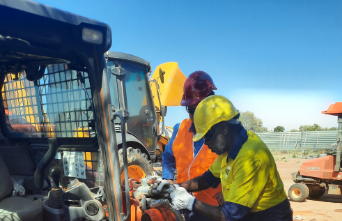 two men work on machinery 