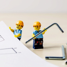 Lego engineers standing among engineering plans