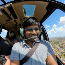 CDU student Sai Ram in a helicopter flying over the outback