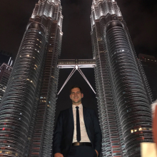 Joel smiling in front of the Petronas Towers in Kuala Lumpur, Malaysia