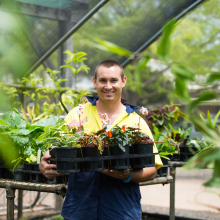 Student holding a tray of plants