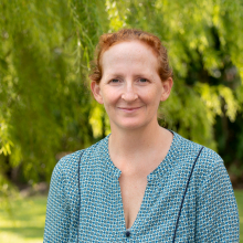 Dr Emily Gibson head and shoulders with green leafy background