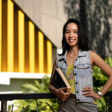 MBA student Ellie holding book on campus