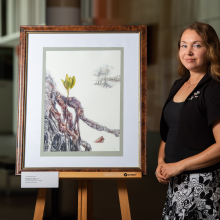 Anastasia Maksimova with the Spotted Mangrove botanical painting that is being exhibited in Kew.