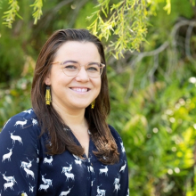 Dr Rebecca Rogers head and shoulders with green leafy vegetation in background