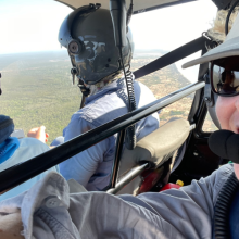 Image of people flying in a helicopter over the land and ocean