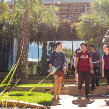 Five students smiling and walking