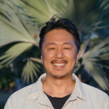 Yusuke Fukuda head and shoulders, with out of focus palm fronds in the background