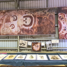 Copies of archival materials exhibited at the Wilinggin Shed in July 2022 with portraits in front and prints of rock art copies in the back